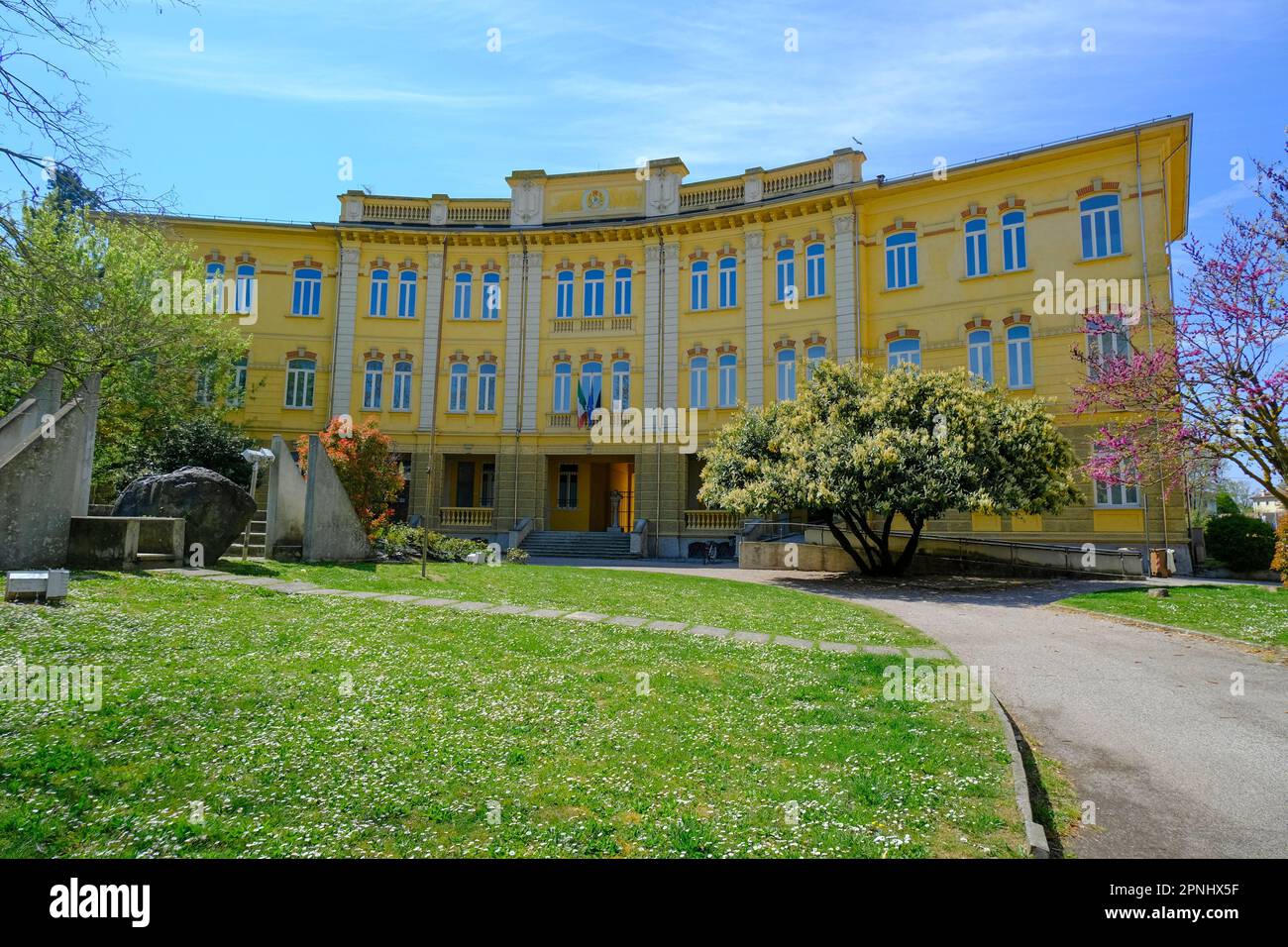 Busseto, Italien: Gelbes Gebäude der Schule und Kriegsdenkmal an einem sonnigen Tag Stockfoto