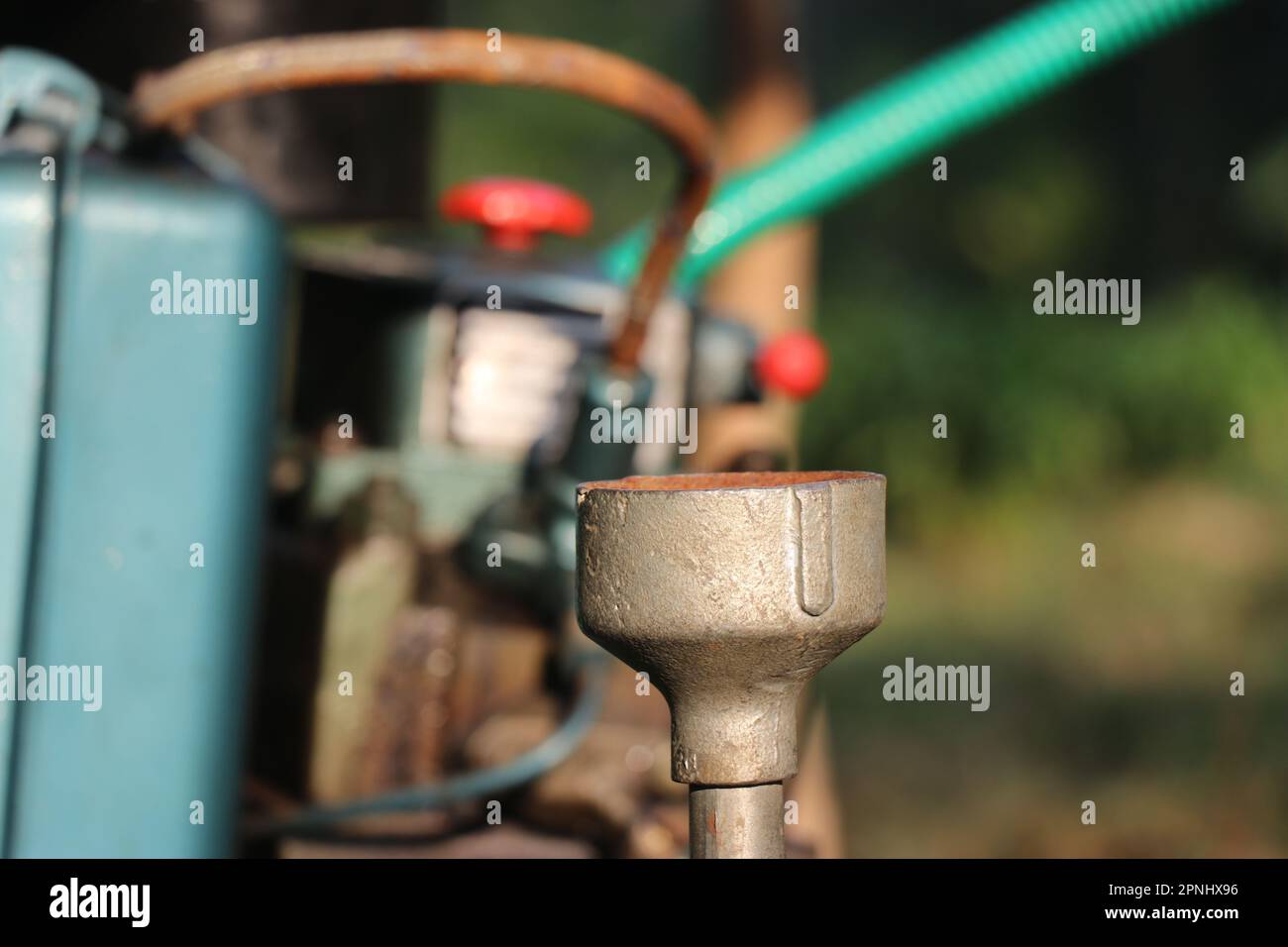 Nahaufnahme des Pumpenrohrs einer Kreiselwasserpumpe mit Blick auf den Dieselmotorsatz im Hintergrund Stockfoto