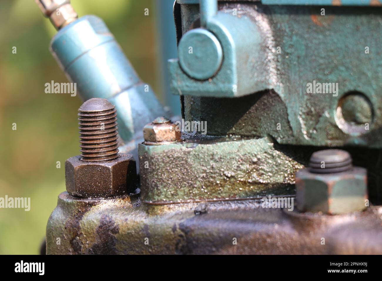 Zylinderkopf des Dieselmotors mit Blick auf Befestigungselemente und Einspritzdüse im Hintergrund Stockfoto