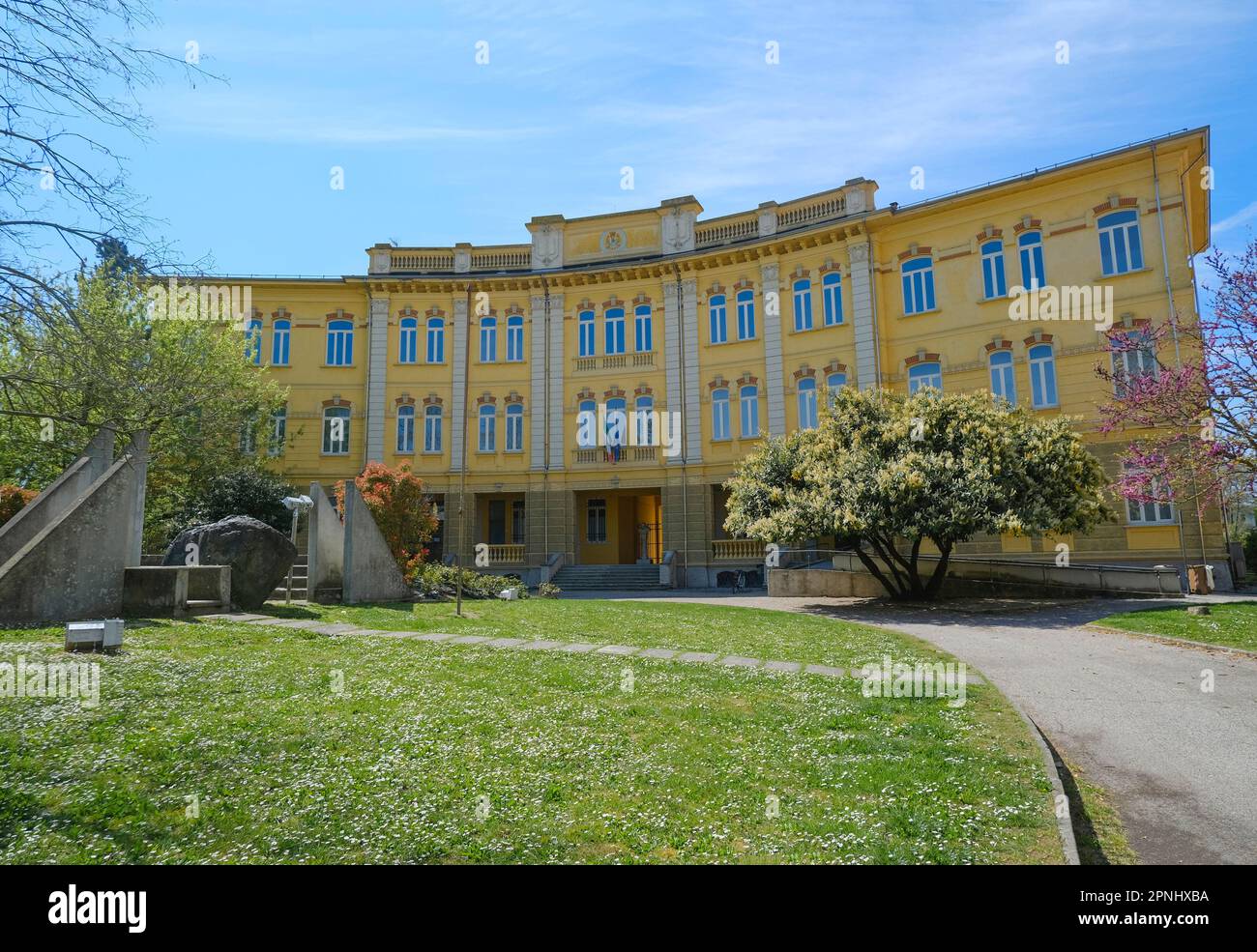 Busseto, Italien: Gelbes Gebäude der Schule und Kriegsdenkmal an einem sonnigen Tag Stockfoto