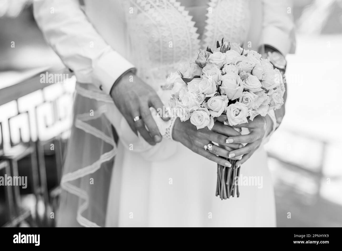 Ein Strauß weißer Blumen in den Händen der Braut. Der Brautstrauß mit weißen Blumen in den Händen einer Frau Stockfoto