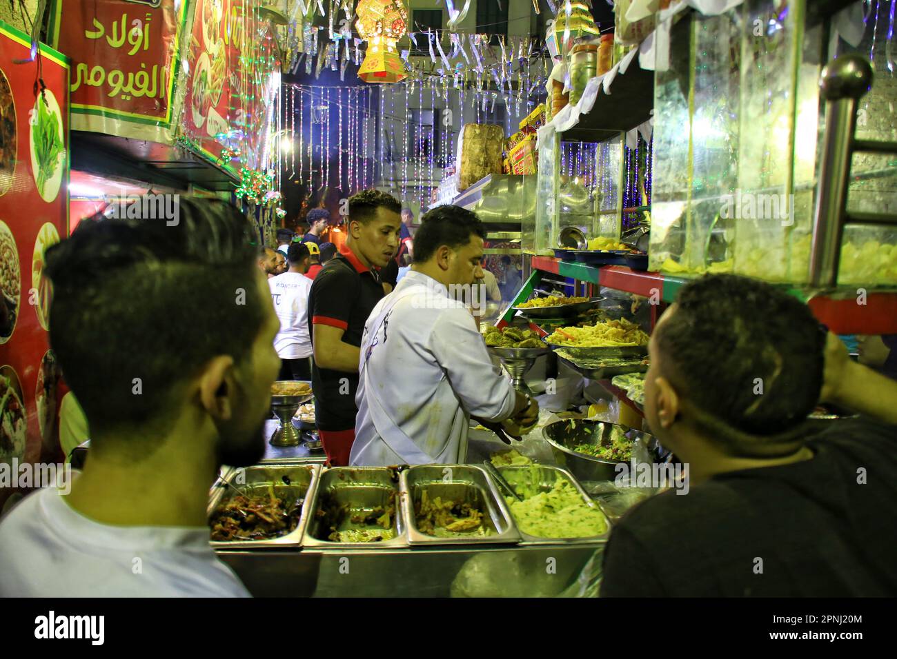 Die Gäste sitzen in einem Straßenrestaurant, um die traditionelle ägyptische Küche „Suhoor“ zu essen, die während des heiligen Monats Ramadan am 19. April 2023 in Kairo, Ägypten, eine Grundausstattung ist. Fasten, während des heiligen Monats des Ramadan, ist eine der fünf Säulen des Islam und ist für alle gesunden Muslime erforderlich. (Foto: Mahmoud Elkhwas/NurPhoto) Kredit: NurPhoto SRL/Alamy Live News Stockfoto