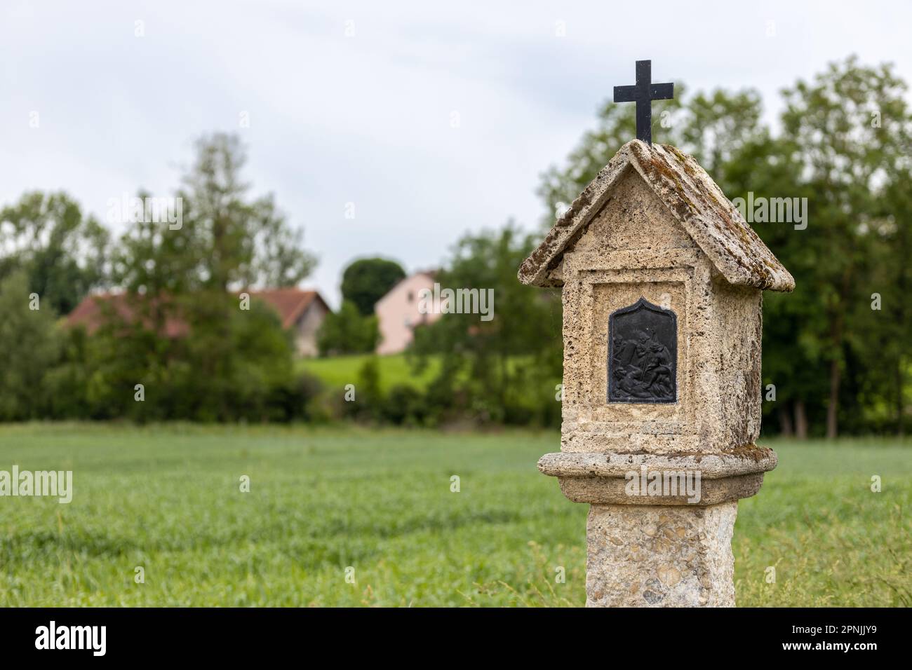 Katholischer Schrein mit religiösem Image und Kurzifix in ländlicher Landschaft im Inn-Tal, Bayern Stockfoto