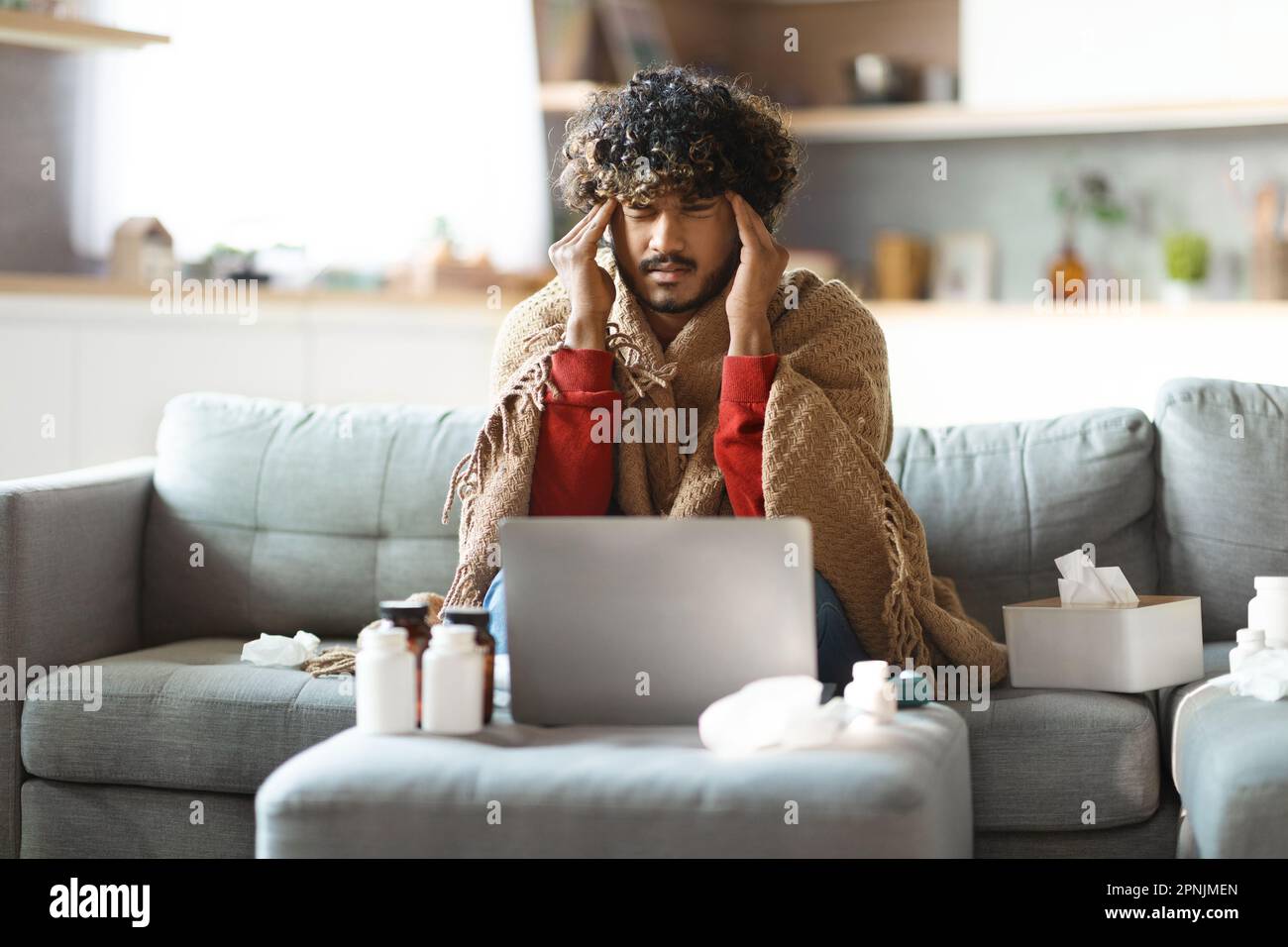 Ein Kranker Indianer Mit Decke, Der Zu Hause Auf Der Couch Sitzt Stockfoto