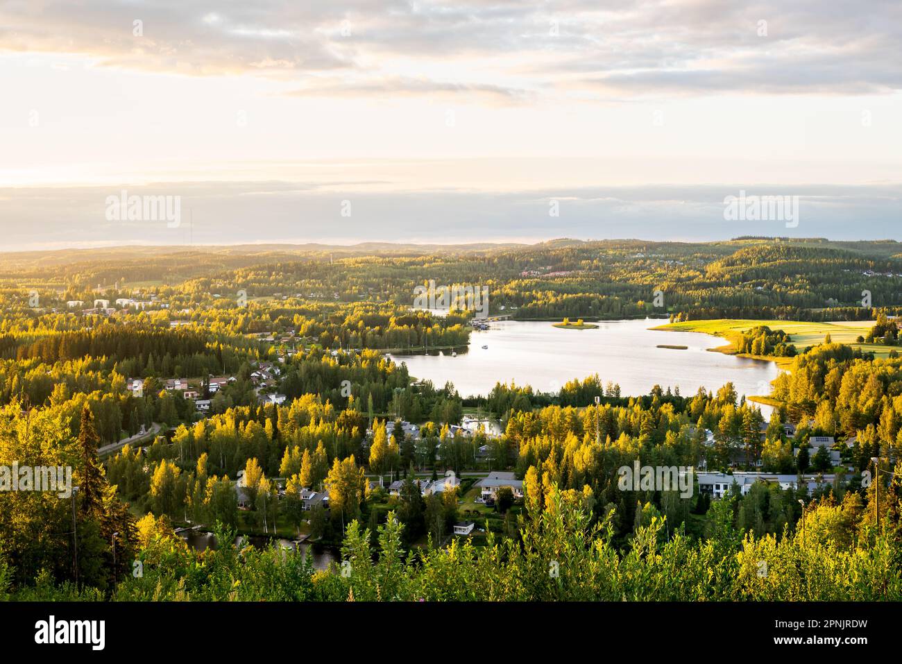 Wald und See in Finnland. Finnische Natur im Sommer. Wunderschöne Landschaft und Luftblick auf die Stadt bei Sonnenuntergang. Nordische Landschaftslandschaft. Stockfoto