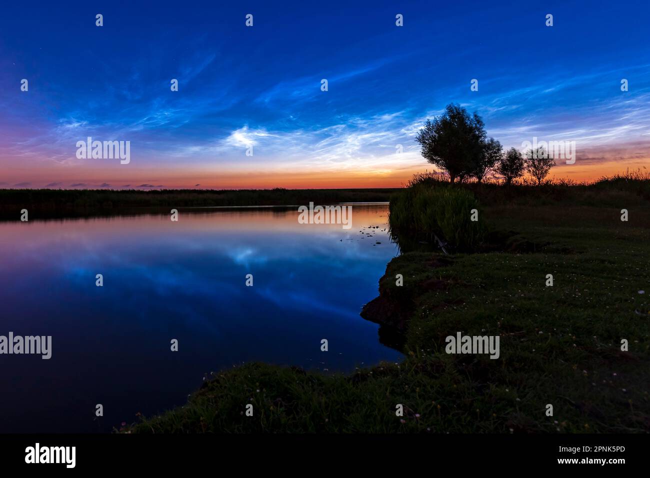 Nächtliche Wolken auch polare mesosphärische Wolken oder nächtliche Wolken reflektieren sich im Wasser Stockfoto