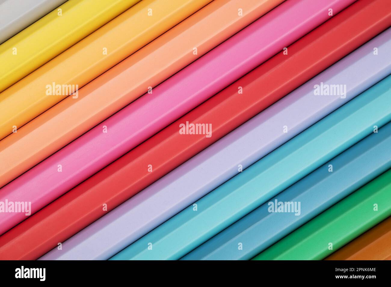 Farbige Bleistifte in Pastelltönen auf pinkfarbenem Hintergrund. Abstrakter Bleistifthintergrund. Mehrfarbige Pastellstifte. Stockfoto