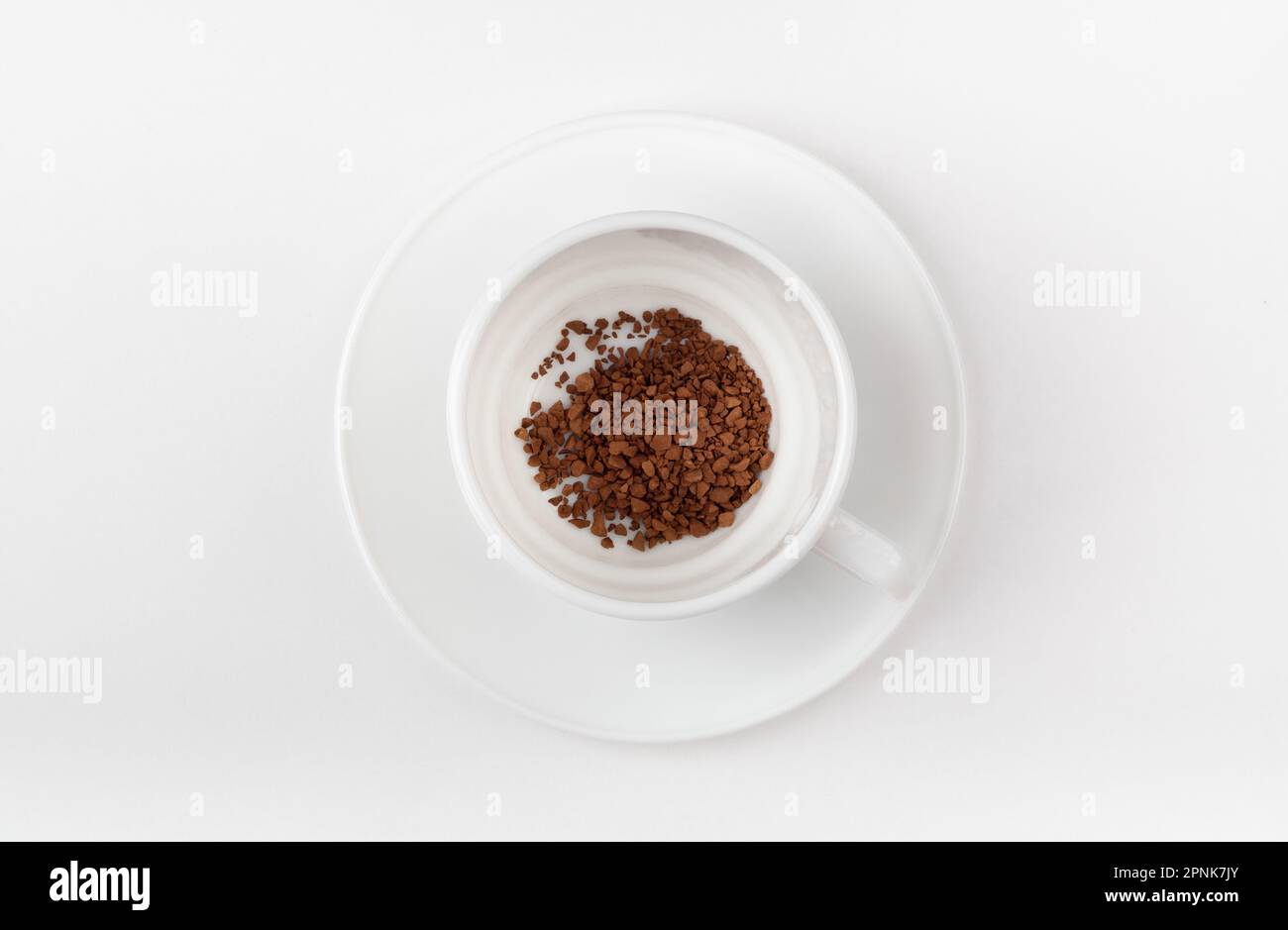 Eine weiße Tasse mit Instantkaffee auf weißem Hintergrund. Leere Tasse. Draufsicht. Stockfoto