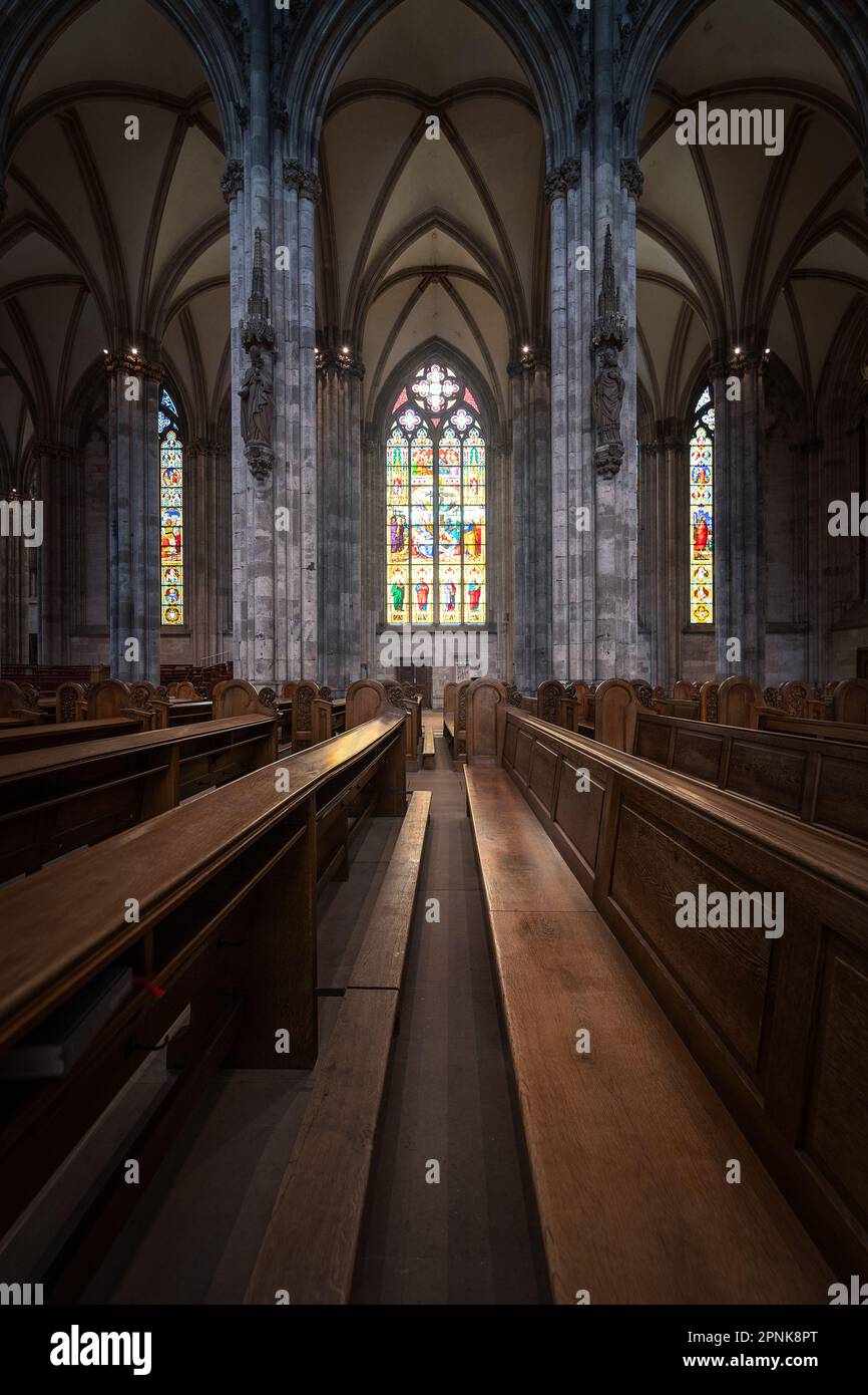 Holzbank und Buntglas in einer Kirche im gotischen Stil Stockfoto