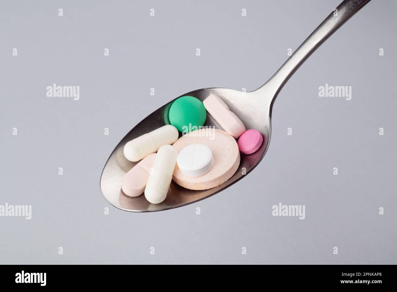 Gemischte pharmazeutische Tabletten, Tabletten und Kapseln auf einem Metalllöffel Stockfoto