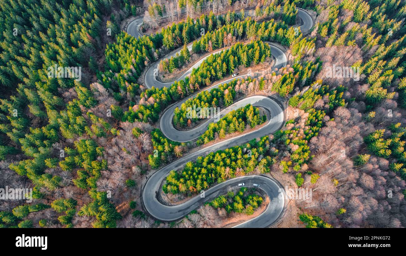 Luftaufnahmen einer gewundenen Straße in den Bergen mit Schlangenlinien und Kurven. Die Fotografie wurde von einer Drohne aus einer höheren Höhe aufgenommen. Stockfoto