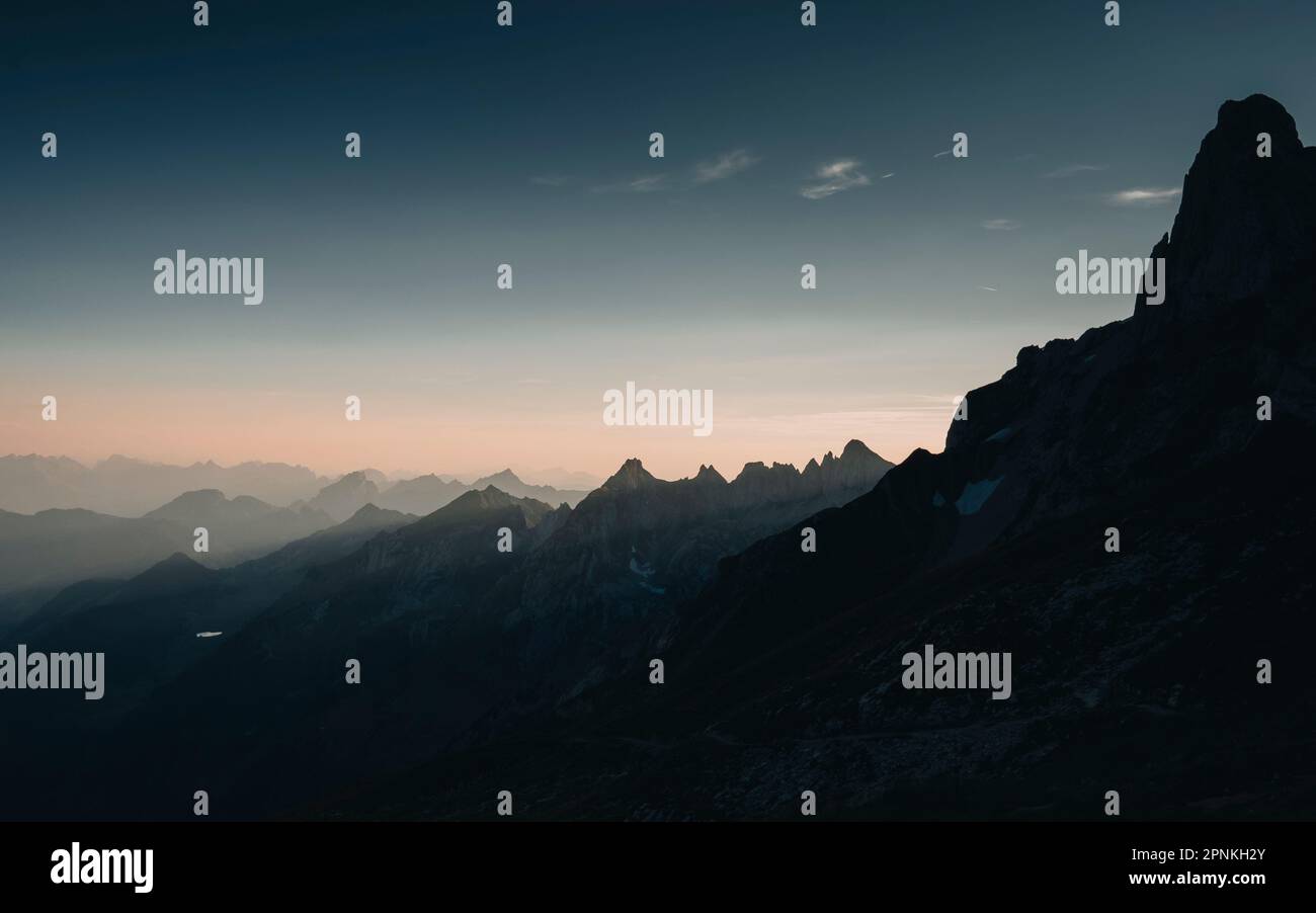 Eine dunkle Bergkette und Lichtstrahlen am Rotsteinpass, alpstein schweiz Stockfoto