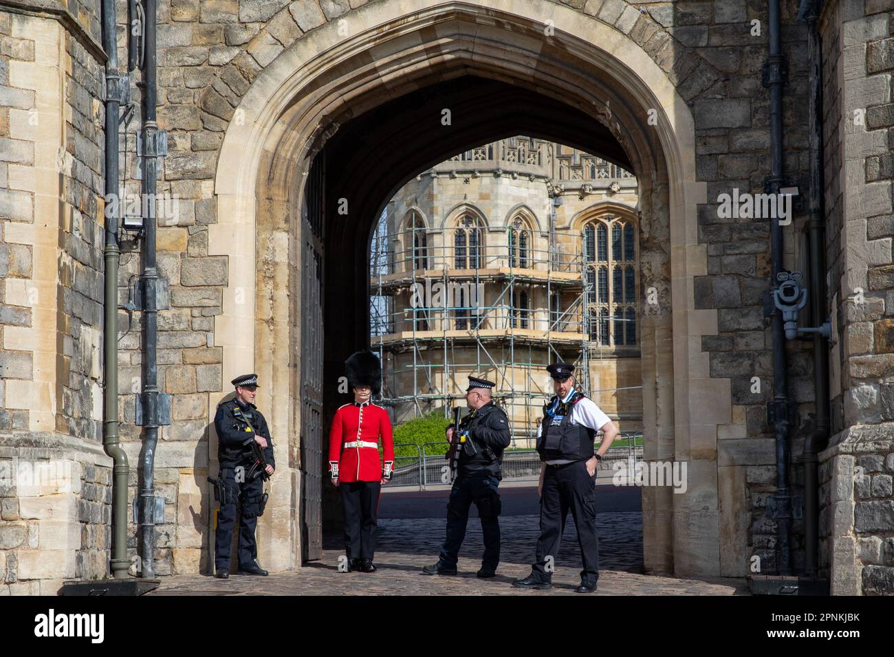 Bewaffnete Polizeibeamte und ein Wachmann sind am 8. April 2023 vor dem Henry VIII Gate in Windsor Castle in Windsor, Großbritannien, zu sehen. Die Wachmänner sind gut ausgebildete Infanteriesoldaten, die neben ihrer Kampfrolle zeremonielle Aufgaben erfüllen. (Foto von Mark Kerrison/in Pictures via Getty Images) Stockfoto