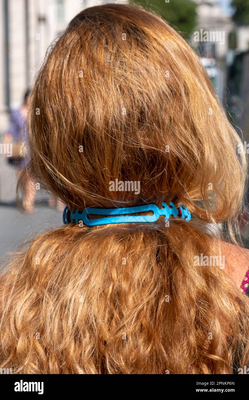 Frau von hinten gesehen, mit einem Maskenhalter am Nacken. Madrid, Spanien Stockfoto