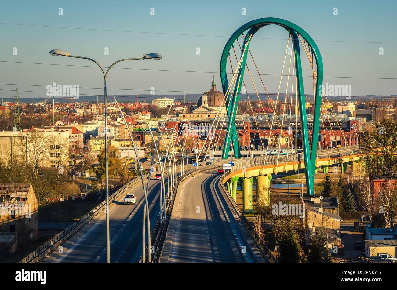 Bydgoszcz, Polen - 17. Februar 2015: Brücke über einen Fluss. Die Kabelbrücke über den Fluss Brda mit Einkaufszentrum und Kirche im Hintergrund, BYD Stockfoto