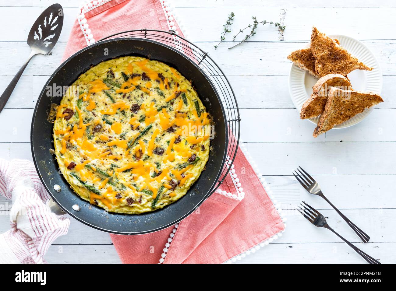 Hausgemachter Speck und Spargelfrittata, garniert mit Käse und serviert mit Toast Stockfoto