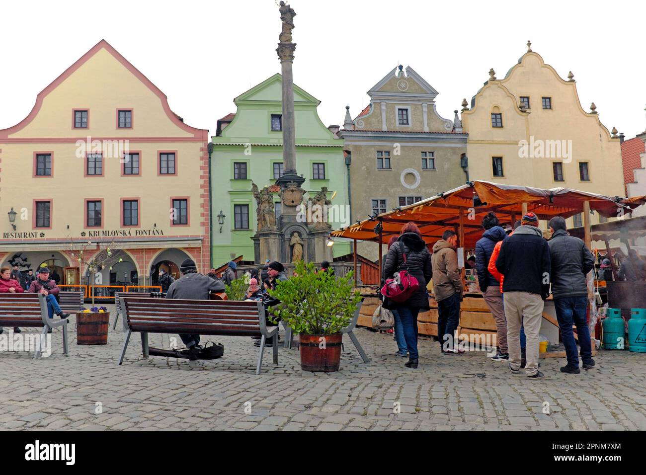 Ein Markt im Freien auf dem Svornosti-Platz in der mittelalterlichen Stadt Ceske Krumlov zieht Besucher wegen seiner historischen Architektur und der Pestsäule an. Die Säule wurde 1716 als Erinnerung an die Beulenpest-Epidemie errichtet, die die Stadt von 1680-1682 heimsuchte. Stockfoto