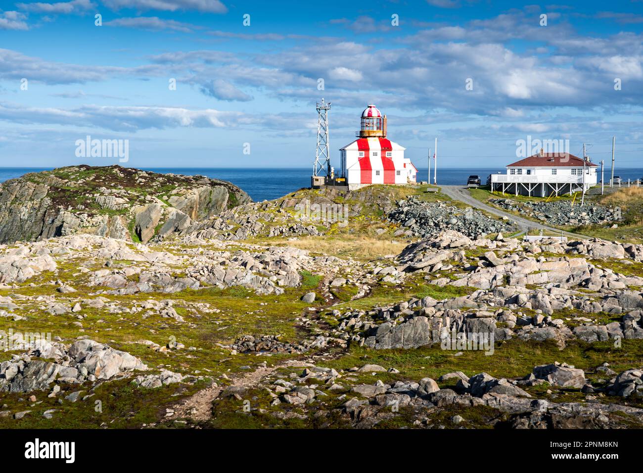 Zerklüftete Küste von Neufundland mit rot-weiß gestreiftem Leuchtturm, beliebte Touristenattraktion am Cape Bonavista Canada. Stockfoto