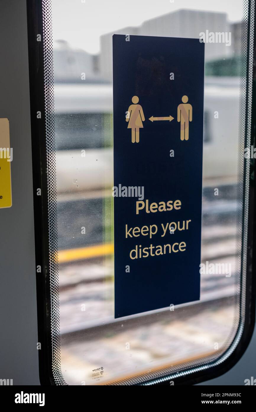 Beschilderung im Zug „Bitte halten Sie Abstand“, Zugfahrt in Südengland Großbritannien Stockfoto