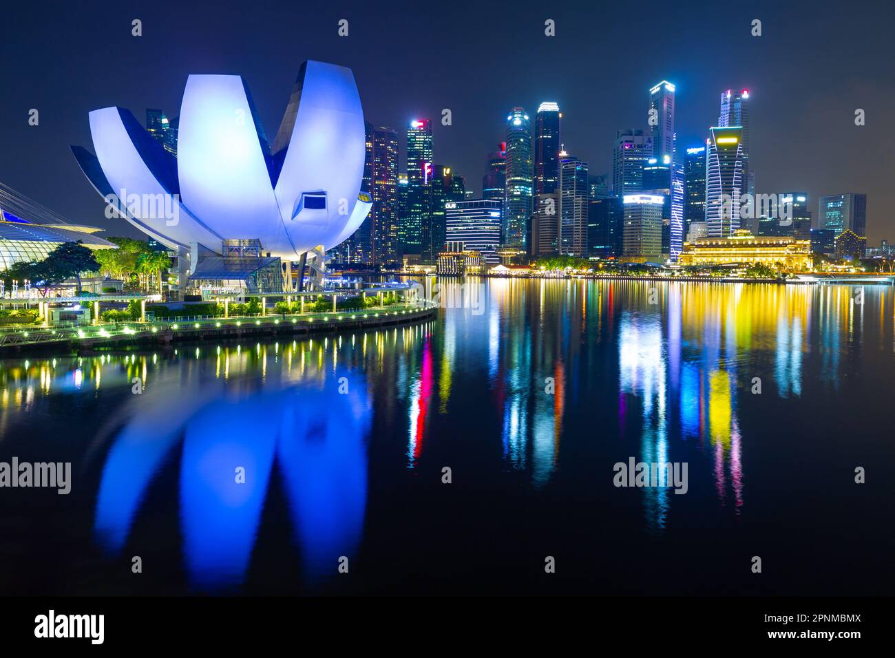 Ein Nachtsicht auf die Marina Bay in Singapur, einschließlich des lotusförmigen Kunstwissenschaftsmuseums und der Skyline des Geschäftsviertels. Stockfoto