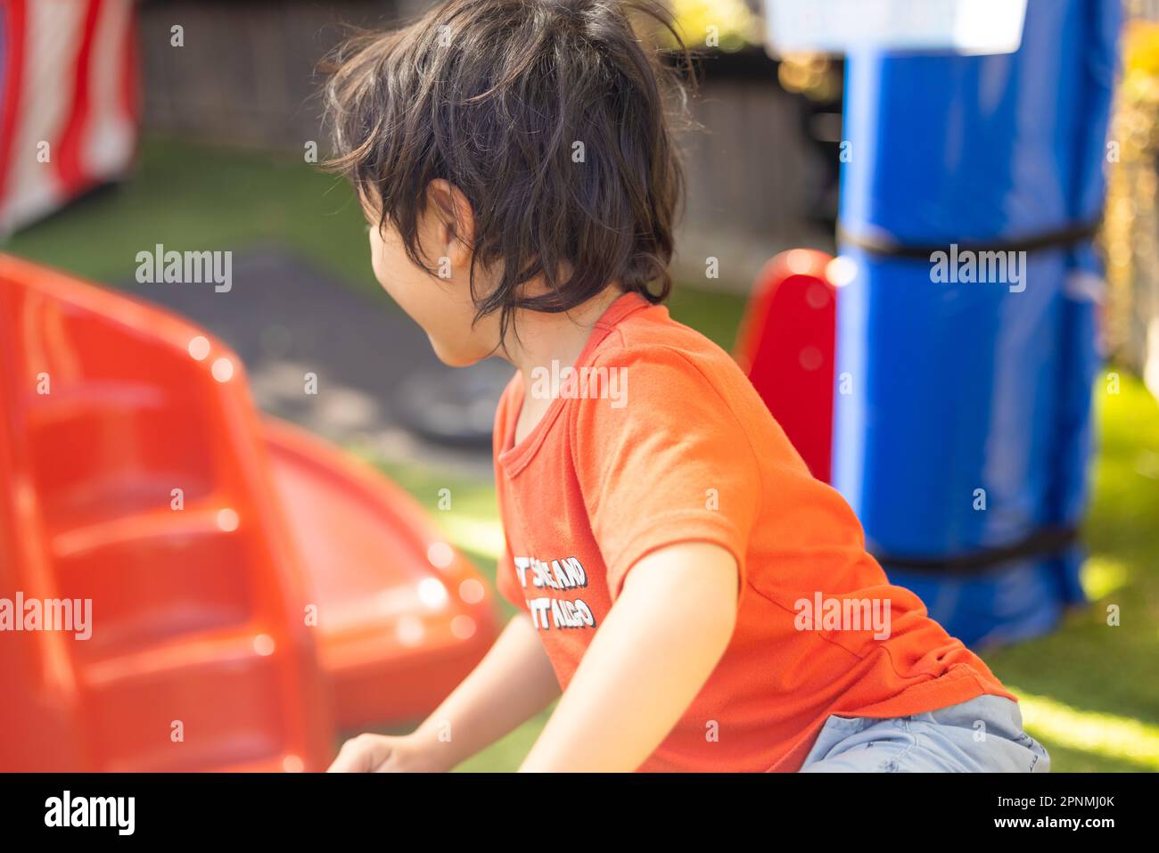 Kinder im Vorschulalter spielen in einem lebhaften Kindergarten im Freien Stockfoto