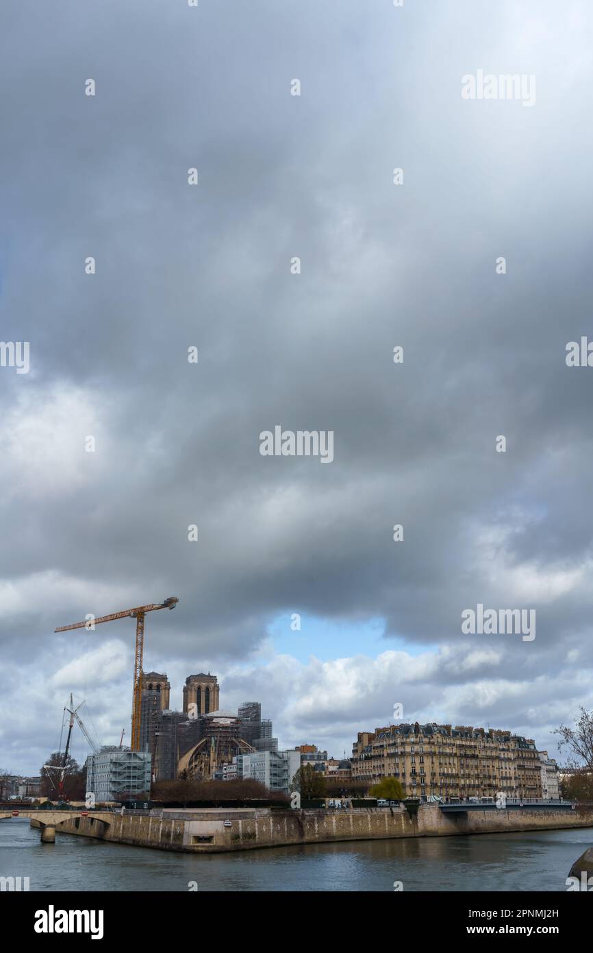 Pariser Stadtbild mit Renovierung von Notre-Dame und der seine. Wolkiger Himmel, Kopierraum. Stockfoto