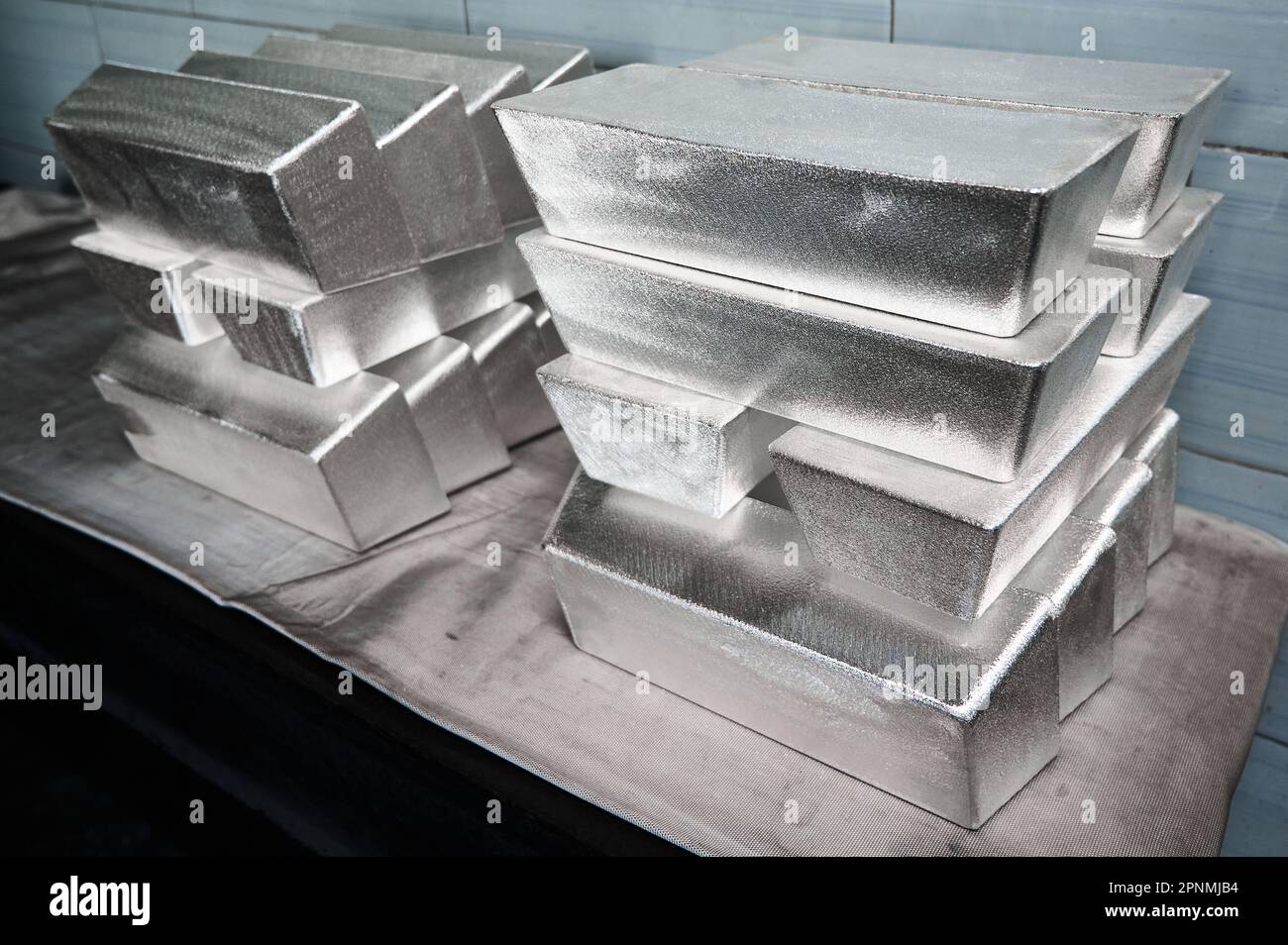 Stapel von industriellen Silberbarren bei hellem Licht im Lager Stockfoto