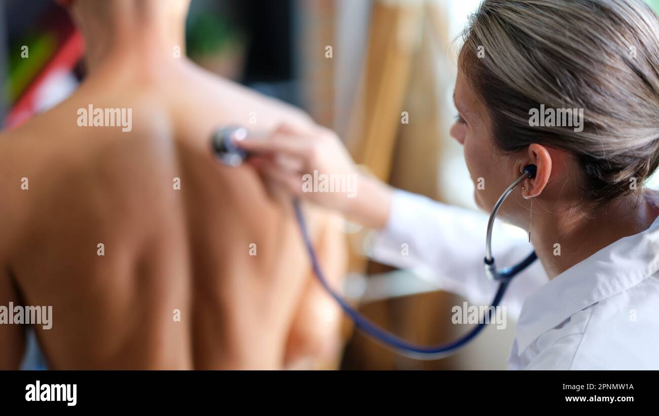 Der Therapeut hört auf den Mann, der mit dem Stethoskop atmet Stockfoto