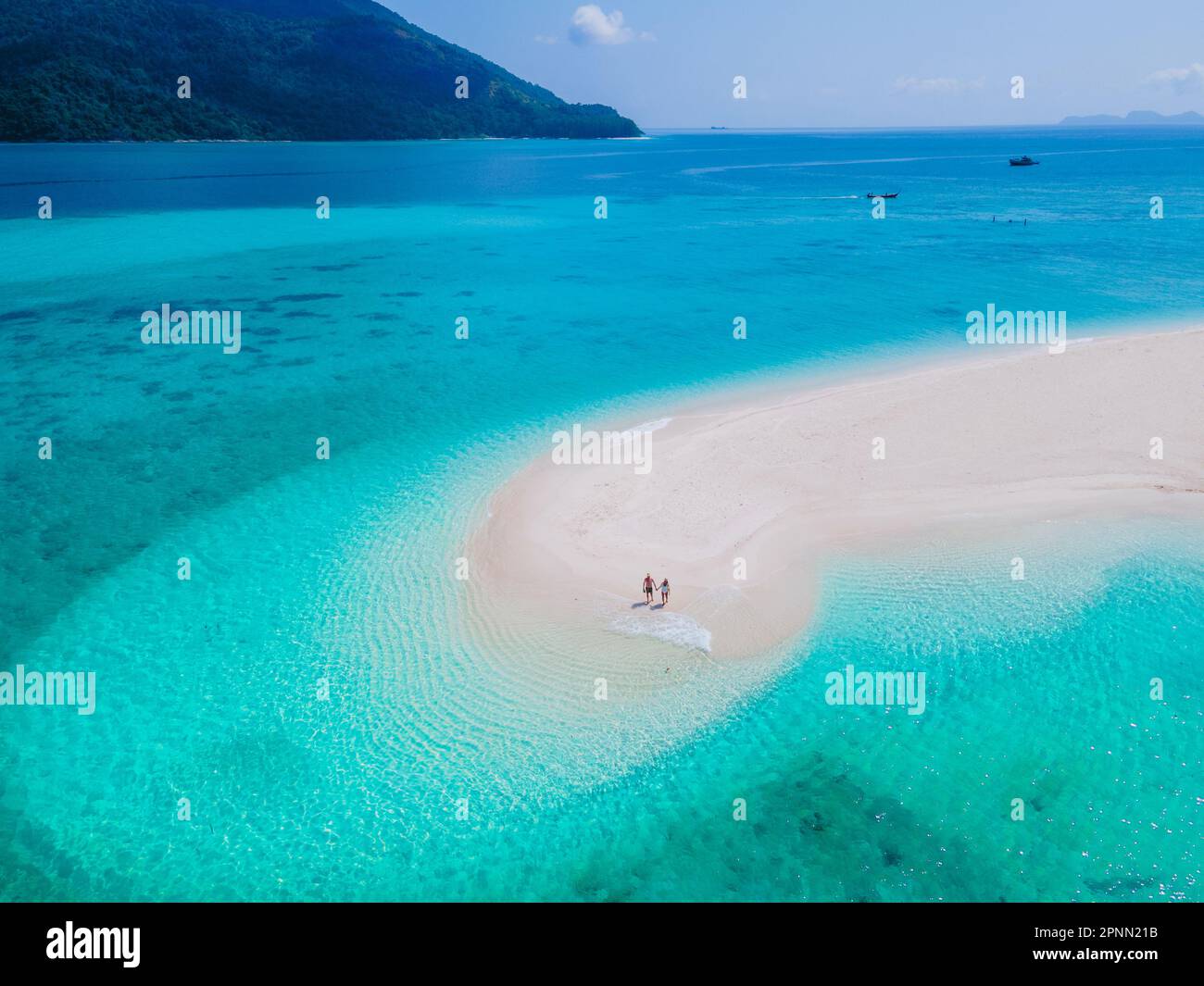 Ein paar Männer und Frauen in einer weißen Sandbank im Ozean von Koh Lipe Island Süd Thailand, mit türkisfarbenem Ozean und weißem Sandstrand Sandbank in Ko Lipe an einem sonnigen Tag Stockfoto