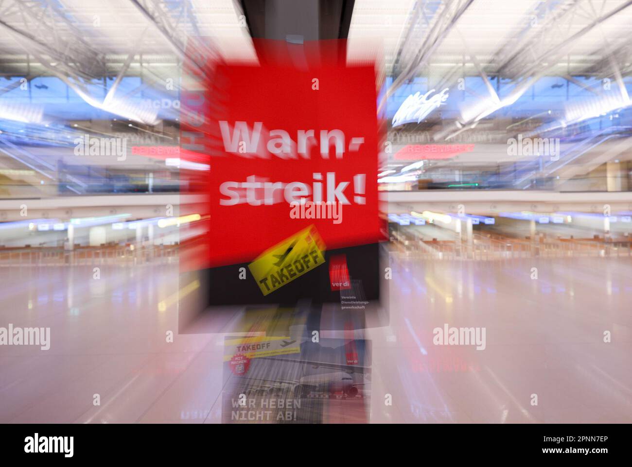 20. April 2023, Hamburg: Ein Poster aus Verdi mit dem Text „Warning Strike today“ hängt auf einer Anzeigetafel in Terminal 1 am Flughafen Hamburg. Die Gewerkschaft Verdi hat auf drei Flughäfen, darunter Hamburg, einen Warnstreik gefordert. Hintergrund für die Warnschläge sind die Verhandlungen zwischen Verdi und dem Bundesverband der Flugsicherheitsgesellschaften (BDLS) über Zeitzuschläge für Nacht-, Samstag-, Sonntag- und Urlaubsarbeit sowie eine bessere Tarifvereinbarung über die Überstundenvergütung für Sicherheits- und Servicepersonal auf kommerziellen Flughäfen. Foto: Christian Charisius/dpa Stockfoto