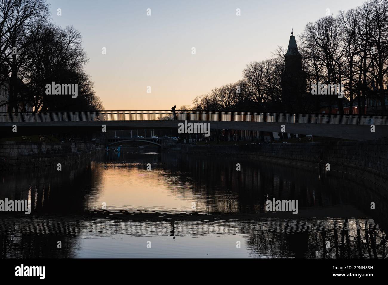 Ein Mann, der morgens auf einer Brücke in Turku, Finnland, im Frühling läuft Stockfoto