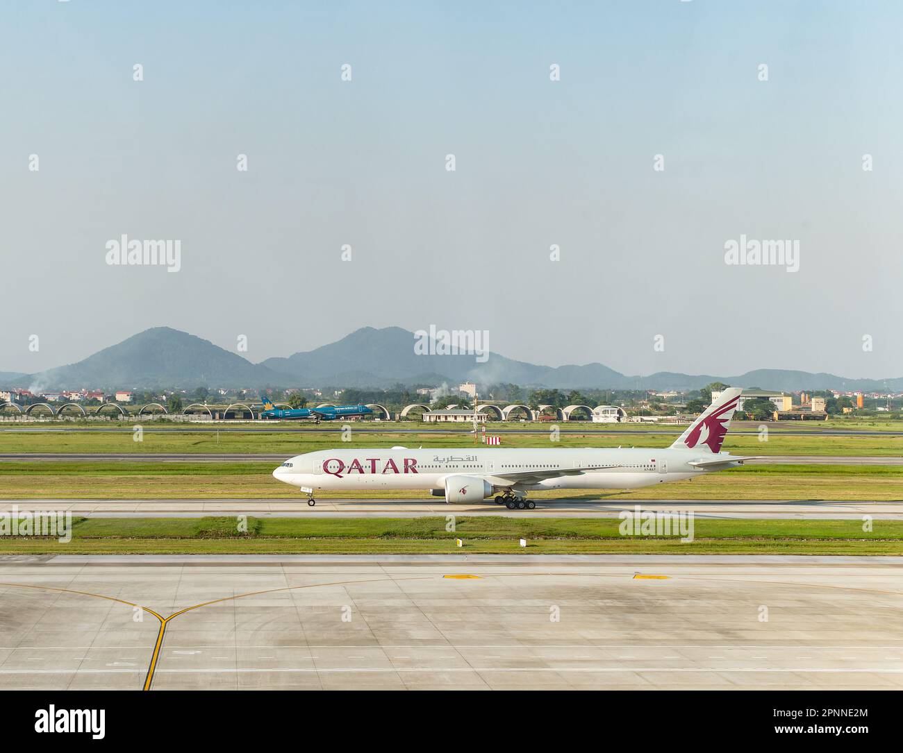 Qatar Airway Boeing 777-300 Taxifahren am Noi Bai International Airport (NIA), dem Hauptflughafen von Hanoi, der Hauptstadt von Vietnam. Vietnam Airlines Airbus Stockfoto