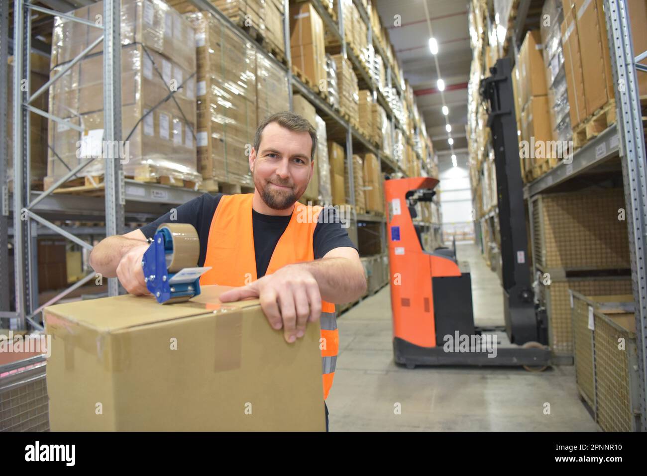 Arbeiter in einem Warenlager im Einzelhandel verpackten ein Paket mit Klebeband Stockfoto