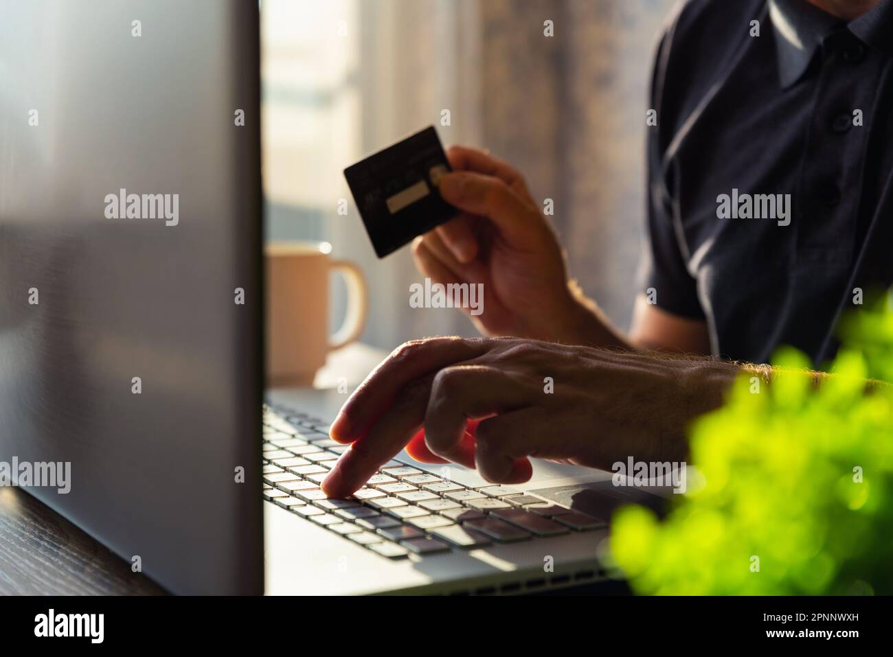 Online-Shopping. Mann mit Kreditkarte und Laptop zu Hause. E-Commerce, Internet-Banking, Home-Office-Konzept Stockfoto