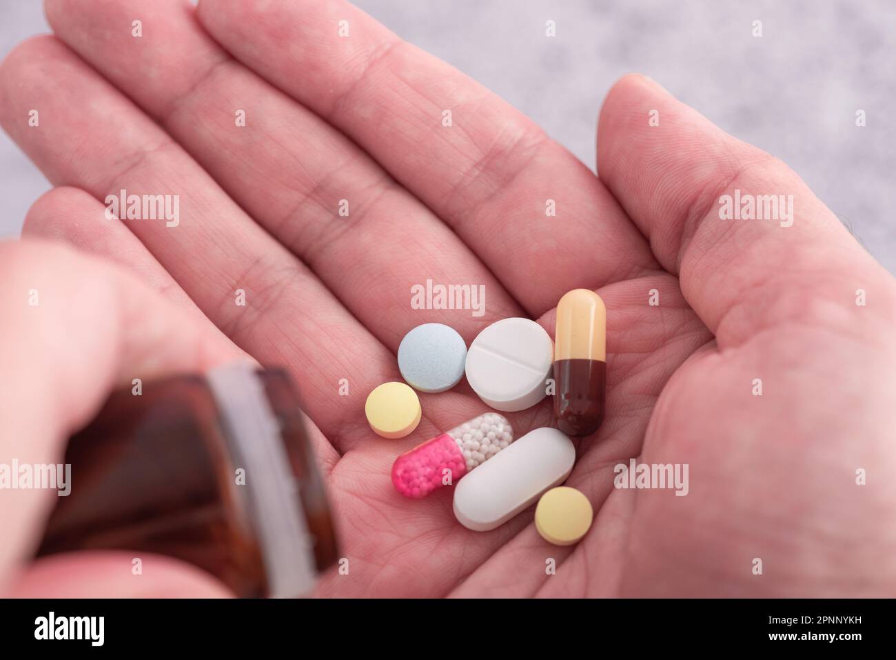 Mann, der verschiedene Arzneimittel-Pillen, Kapseln und Tabletten einnimmt. Medikamentendosis für den Behandlungsverlauf der männlichen Handfläche. Schließen. Medikamente, Gesundheitsfürsorge, Treatment Stockfoto