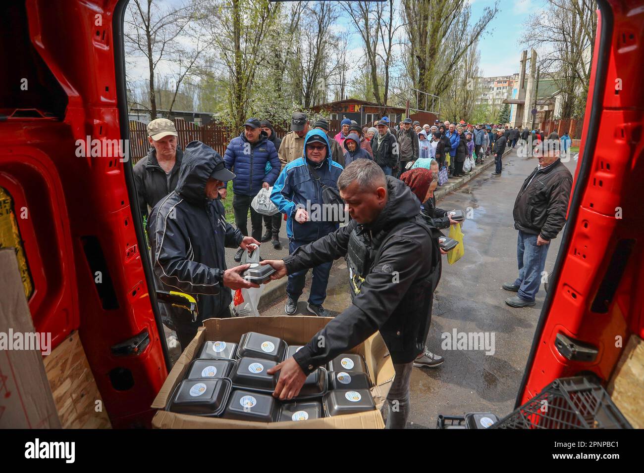 Kherson, Ukraine. 19. April 2023. Nach dem russischen Bombenanschlag in Kherson warten die Menschen in einer Schlange, um humanitäre Nahrungsmittelhilfe zu erhalten. Obwohl die ukrainischen Streitkräfte russische Truppen aus der Stadt verdrängten und während der Befreiung Mitte November Jubelszenen auslösten, zogen sich die russischen Streitkräfte nur über den Fluss Dnipro zurück und schossen Kherson täglich weiter. Kredit: SOPA Images Limited/Alamy Live News Stockfoto