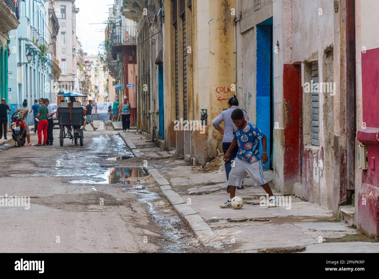 Havanna, Kuba - 12. April 2023: Menschen auf schmutzigen Straßen und Gehwegen Stockfoto
