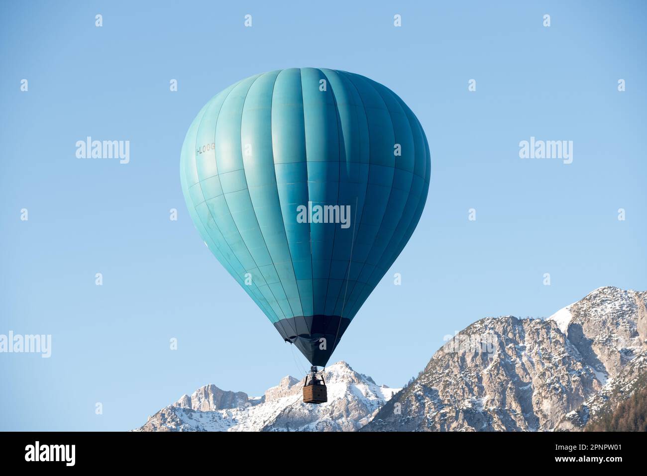 una bella mongolfiera prende il volo bei una limpida mattinata in montagna nelle dolomiti Stockfoto
