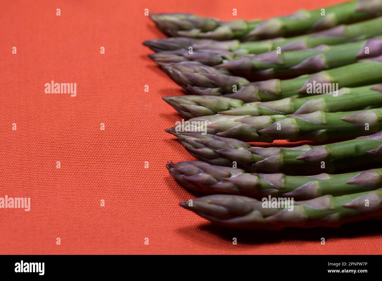Muster Creato con Asparagi verdi su sfondo Arancione Stockfoto