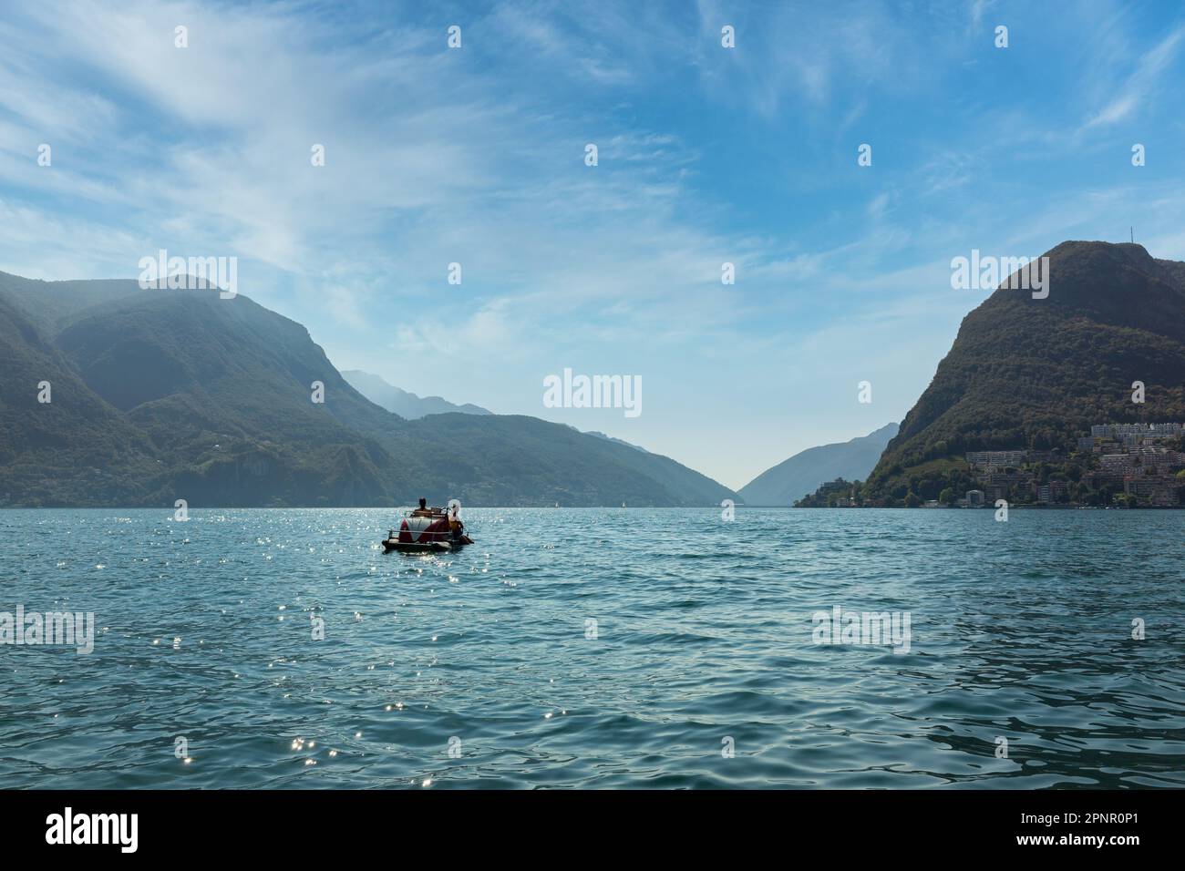 Entfernte Rückansicht von zwei Frauen, die in einem Paddelboot segeln, Luganer See, Schweiz Stockfoto