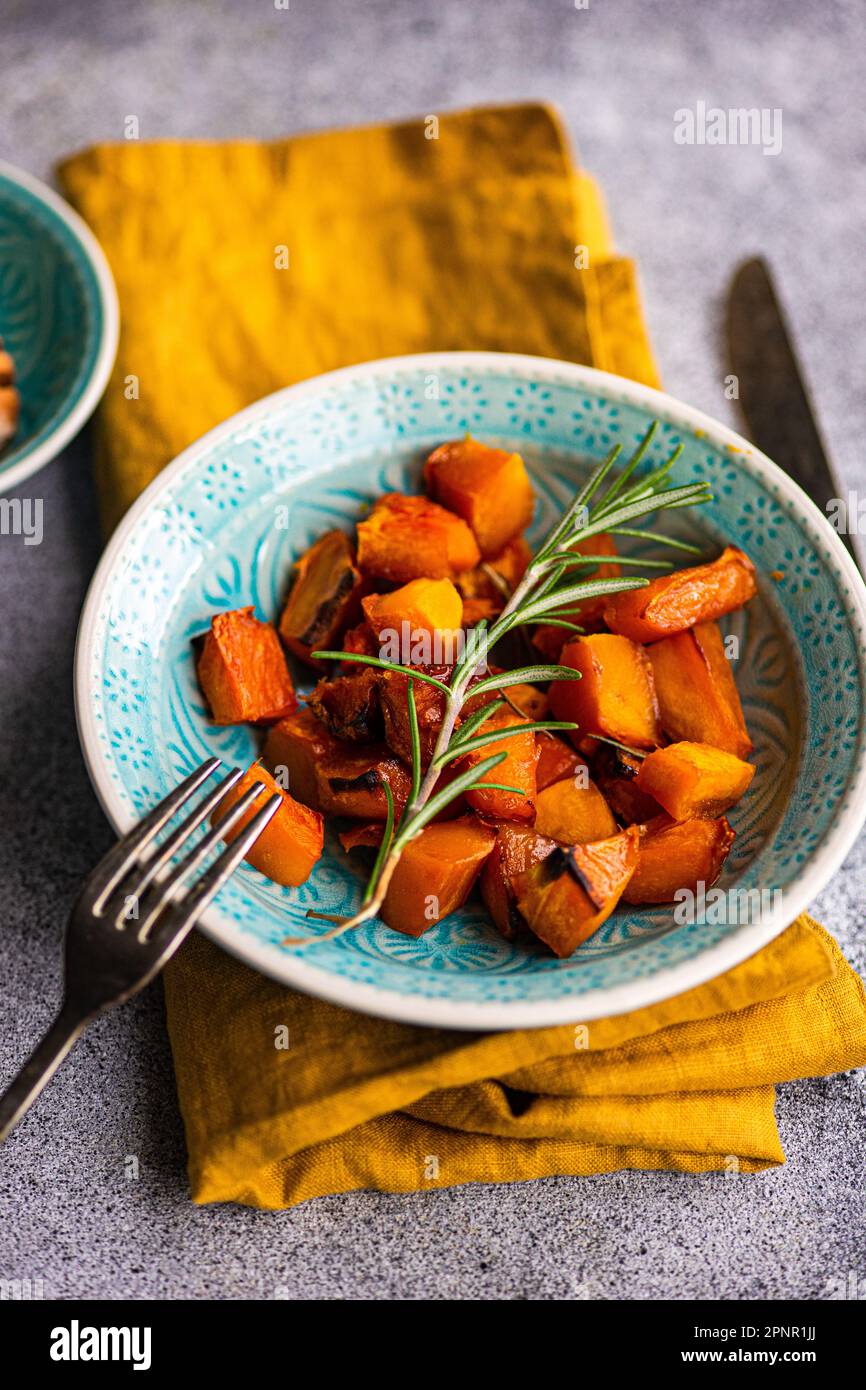 Nahaufnahme einer Schüssel gerösteter Kürbis auf einem Tisch Stockfoto
