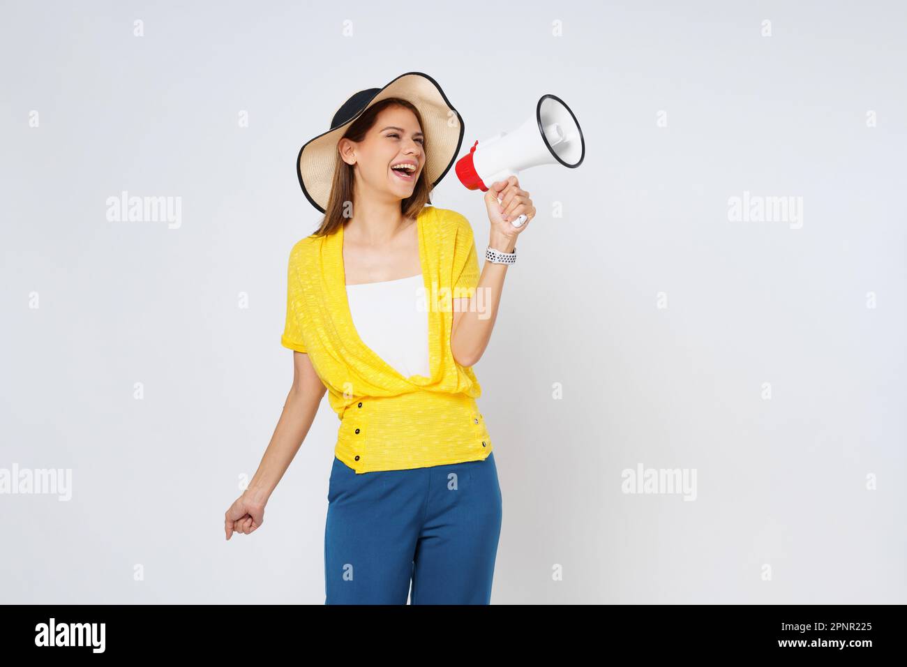 Junge Frau mit Sonnenhut und Megafon isoliert auf weißem Hintergrund. Lifestyle-Sommer- und Ankündigungskonzept. Stockfoto