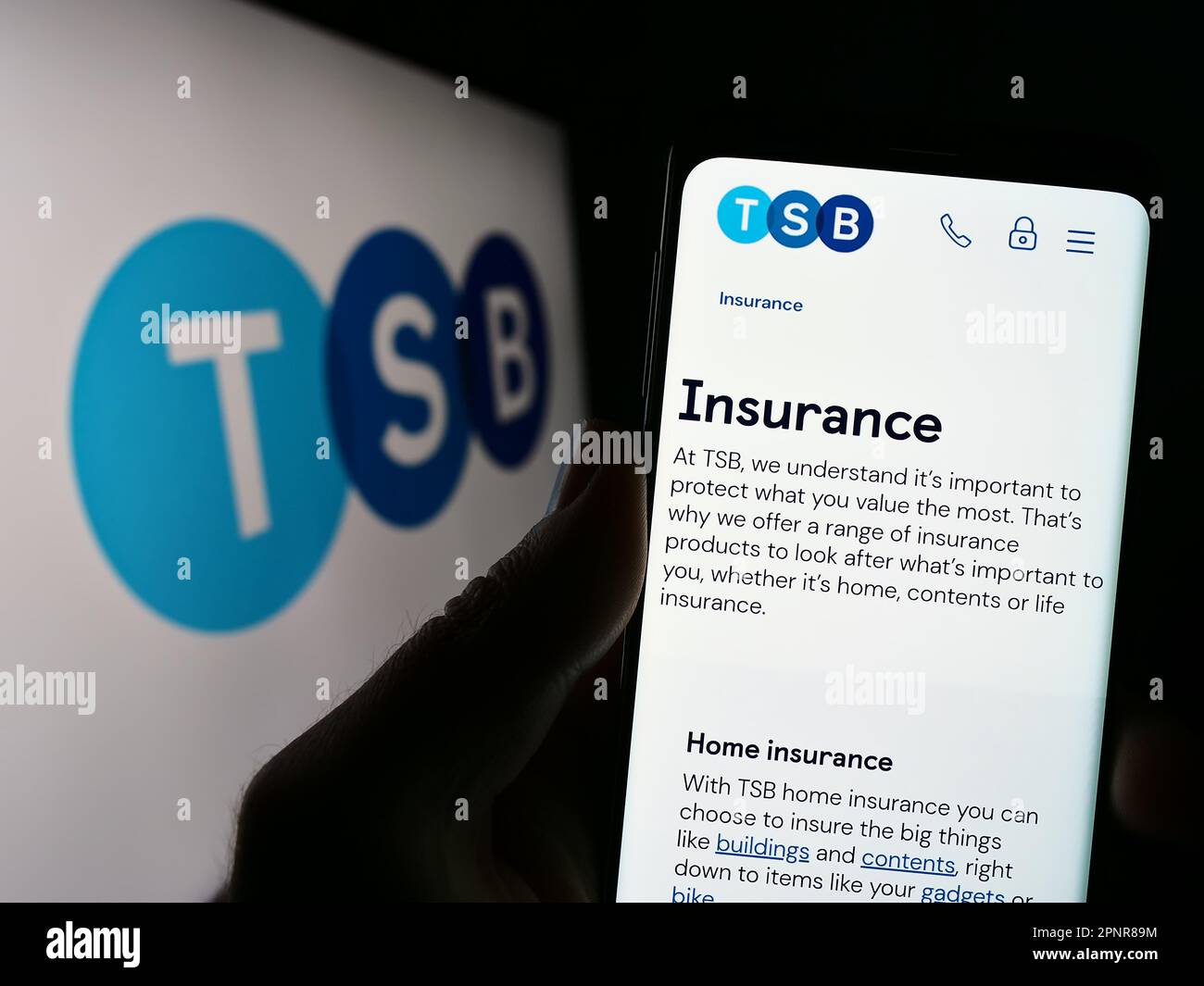 Person, die ein Mobiltelefon mit einer Webseite des britischen Finanzunternehmens TSB Bank plc auf dem Bildschirm vor dem Logo hält. Konzentrieren Sie sich auf die Mitte des Telefondisplays. Stockfoto