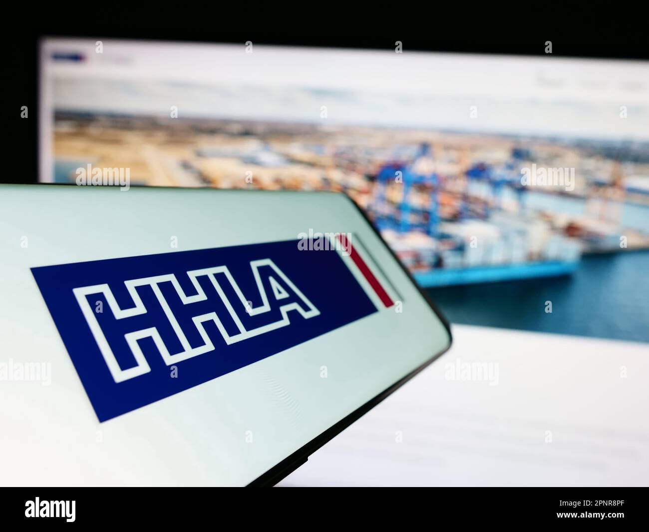 Handy mit Logo der Firma Hamburger Hafen und Logistik AG (HHLA) auf dem Bildschirm vor der Website. Fokus auf die Mitte links des Telefondisplays. Stockfoto