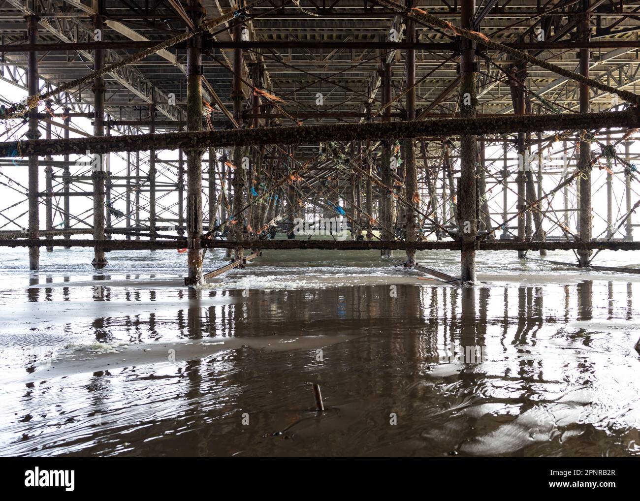 Under Hastings Pier unterstützt mit Reflexionen Stockfoto