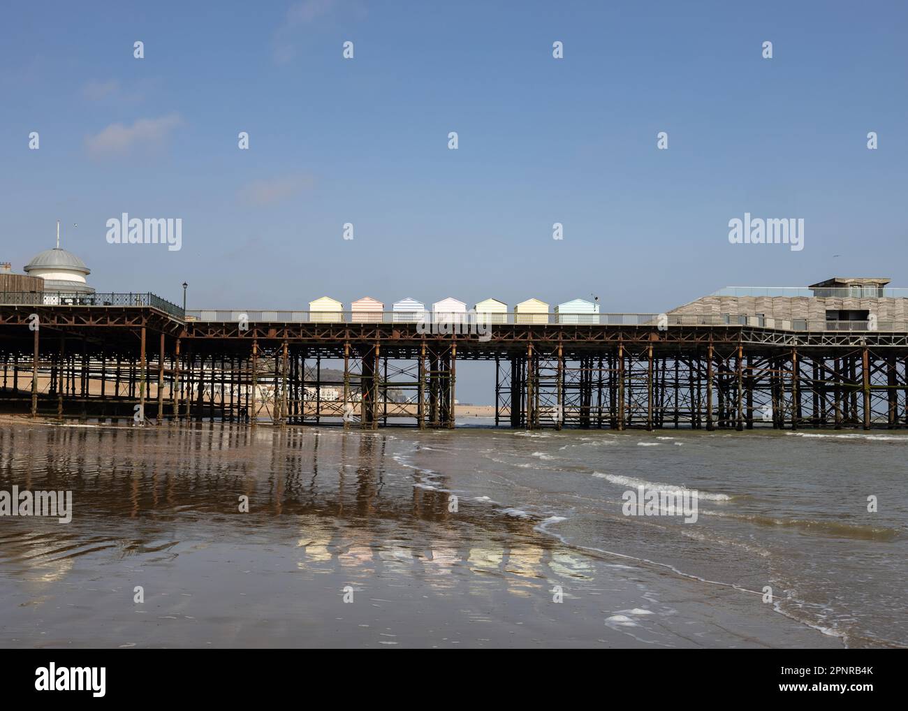 Hastings Pier Strandhütten mit Reflexion Stockfoto