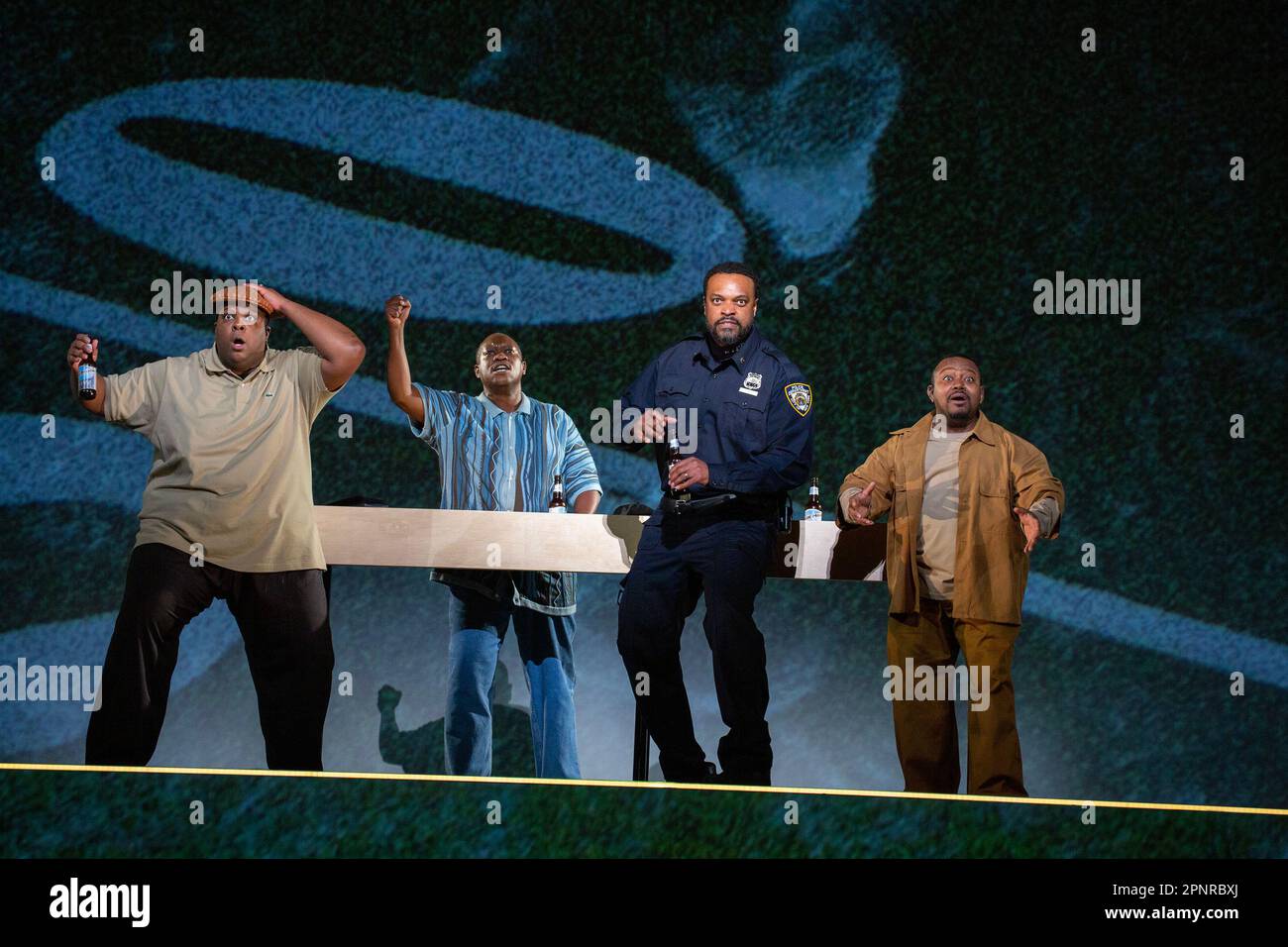 Beim Fußballspiel - l-r: Joshua Conyers (Polizist 3), Rheinaldt Tshepo Moagi (Polizist 2), Kenneth Kellogg (der Vater), John-Colyn Gyeantey (Polizist 1) in BLAU, Eröffnung an der englischen Nationaloper (ENO), London Coliseum, London WC2 20/04/2023 Musik: Jeanine Tesbretewell, Thcodori Design: Alex Lode Videodesign: Ravi Deepres Beleuchtung: James Farncombe Choreographie: Ingrid Mackinson Regisseur: Tinuke Craig Stockfoto