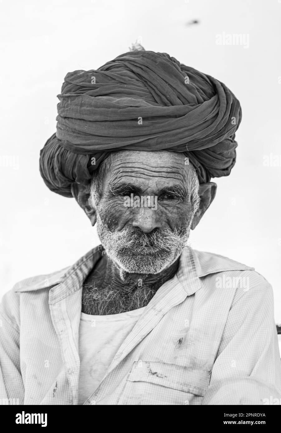 Pushkar, Indien - Okt. 2022: Pushkar-Messe, Portrait eines alten rajasthani-Mannes mit traditionellem weißen Kleid und farbenfrohem Turban auf dem pushkar-Messegelände Stockfoto