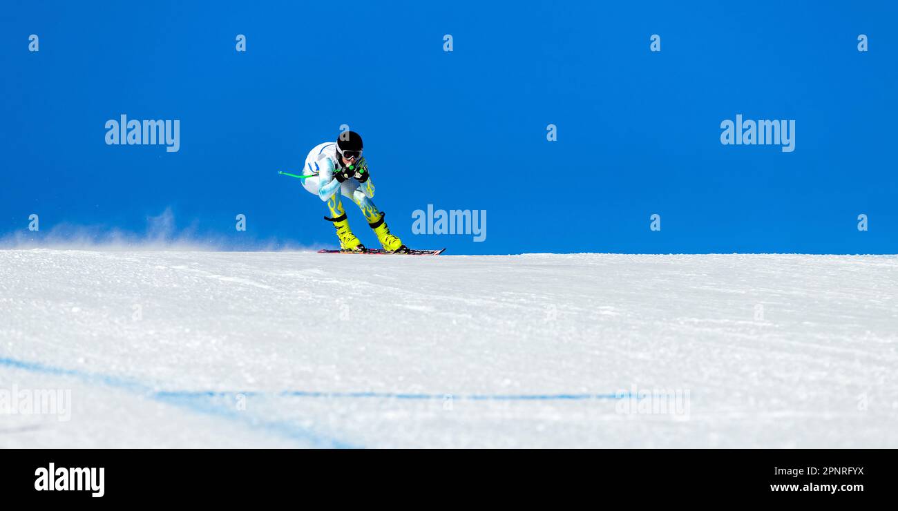 Männlicher Skifahrer auf alpiner Skipiste, schneebedeckte Piste am blauen Himmel, Wintersportspiele Stockfoto