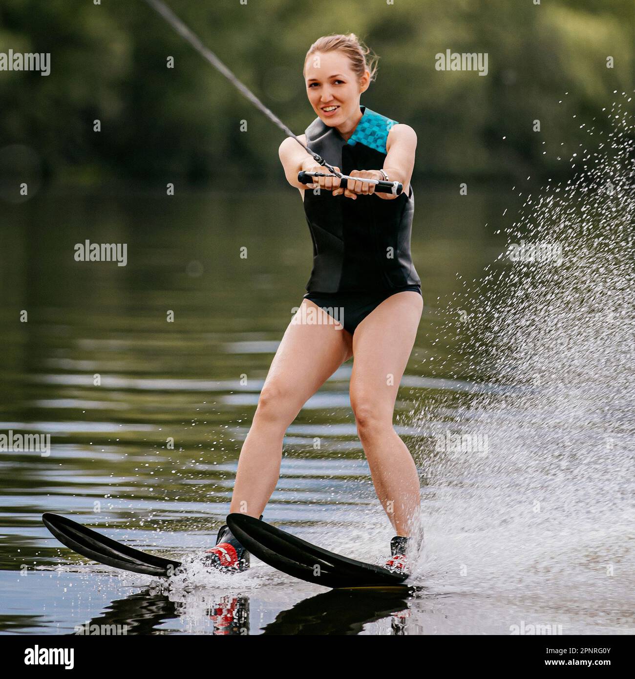 Junge Frau mit mysteriösem Aussehen beim Wasserski auf dem Teich, fröhlicher Sommerurlaub Stockfoto